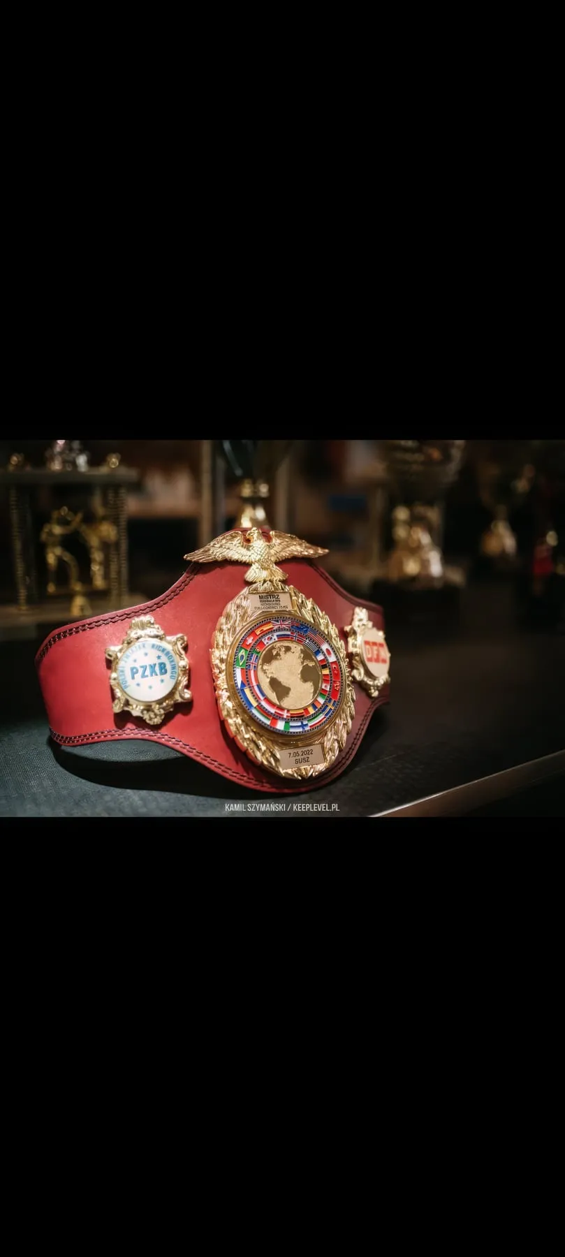 Czerwony pas mistrzowski z plakietką Polskiego Związku Kickboxingu
